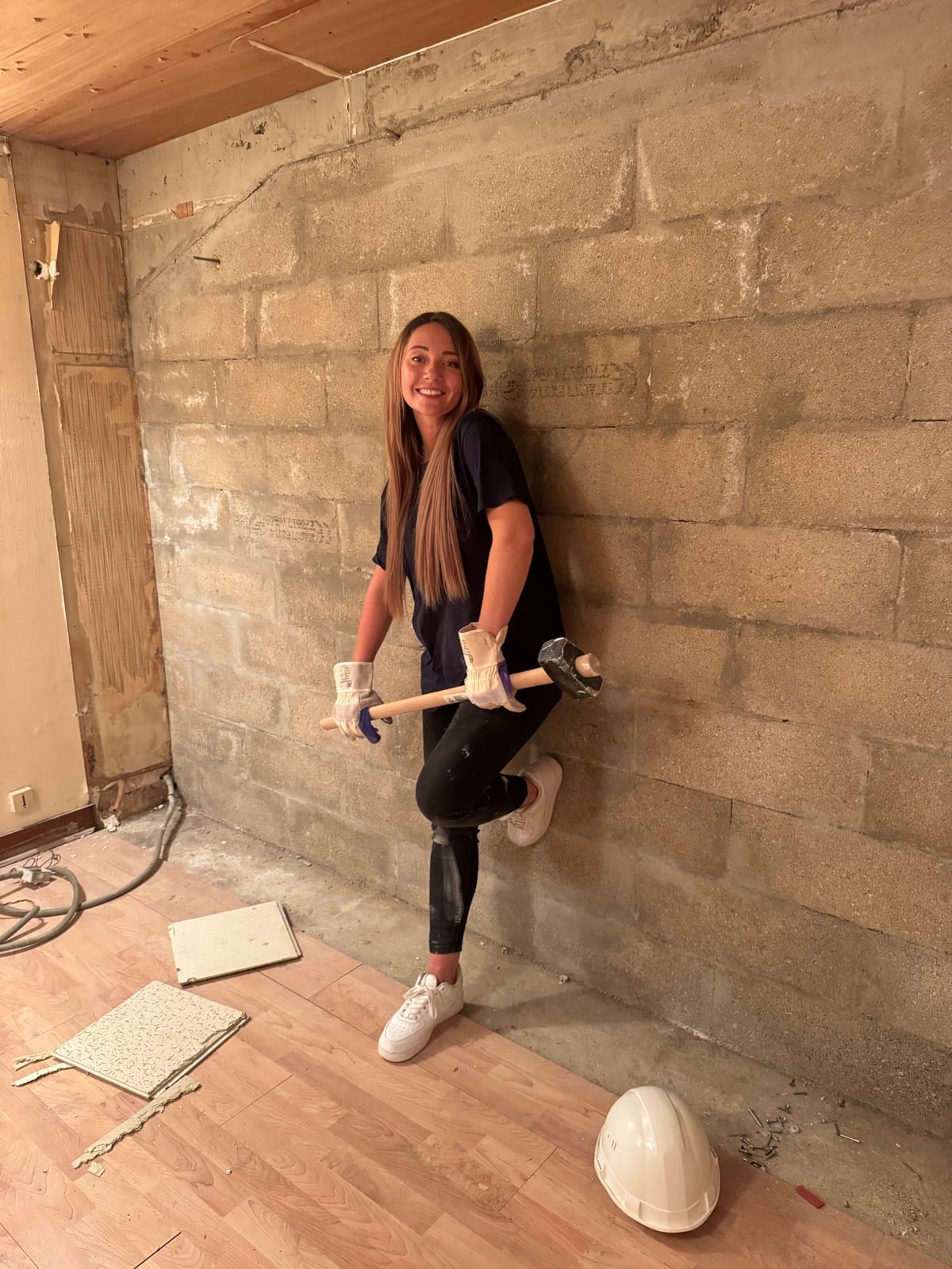 Emeline avec une masse sur un chantier