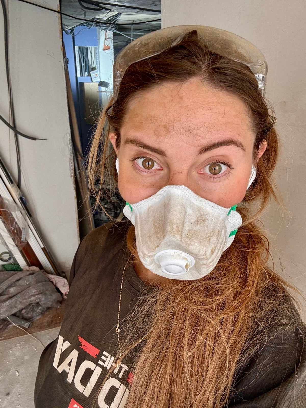 Emeline avec un masque de poussière sur un chantier