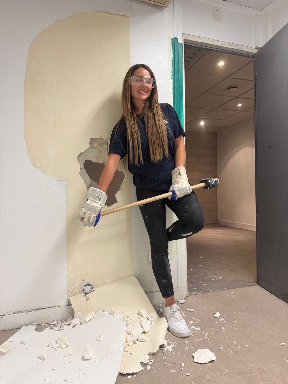 Emeline Siron en plein travaux de rénovation, marteau en main