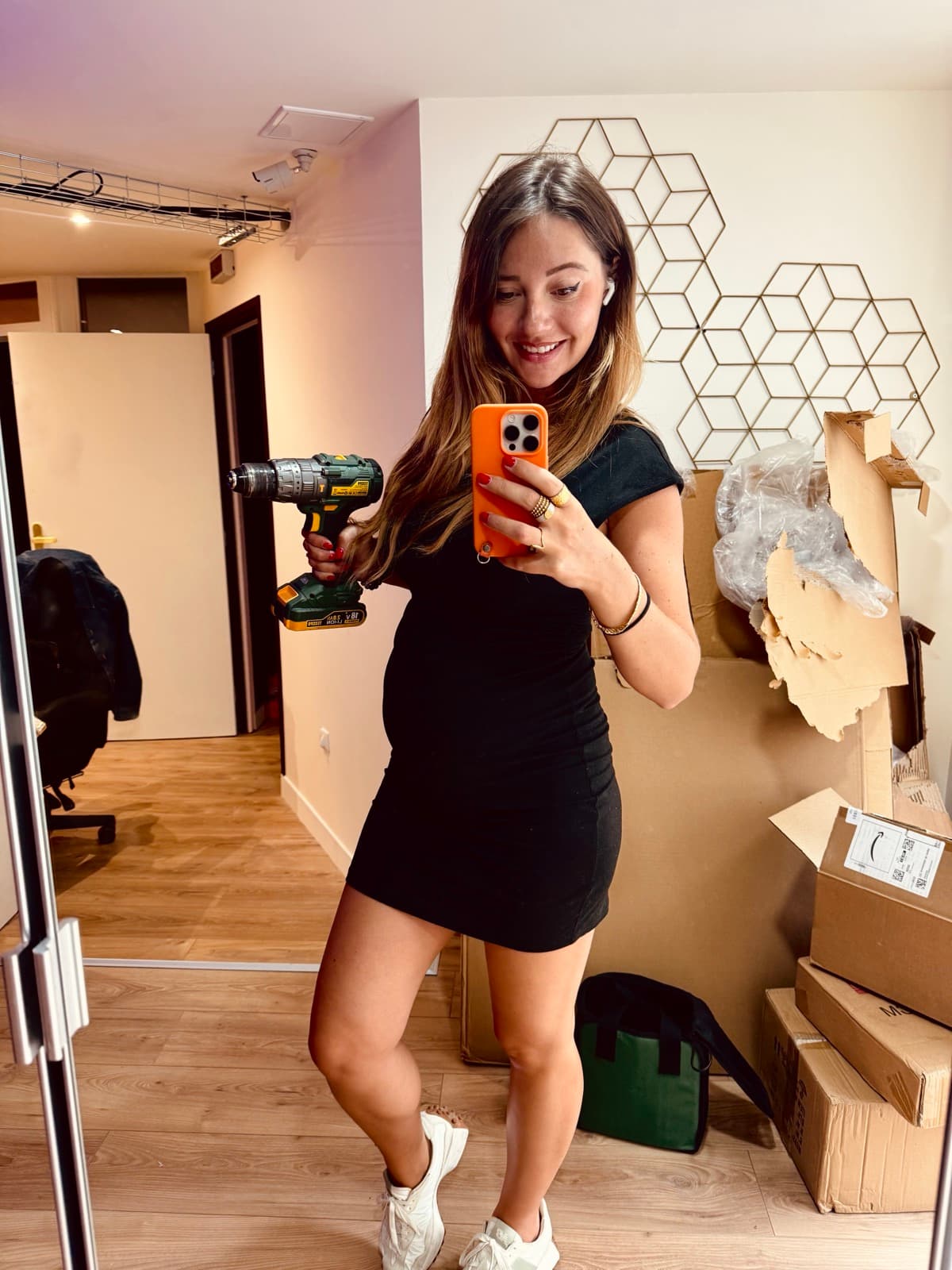 Emeline perceuse en main devant un mur en travaux